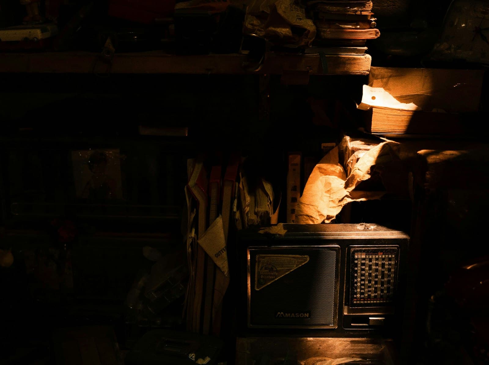 Une radio vintage dans un grenier en cours de débarras, éclairée par un rai de soleil.